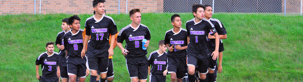 Photo of boys soccer team walking onto playing field.
